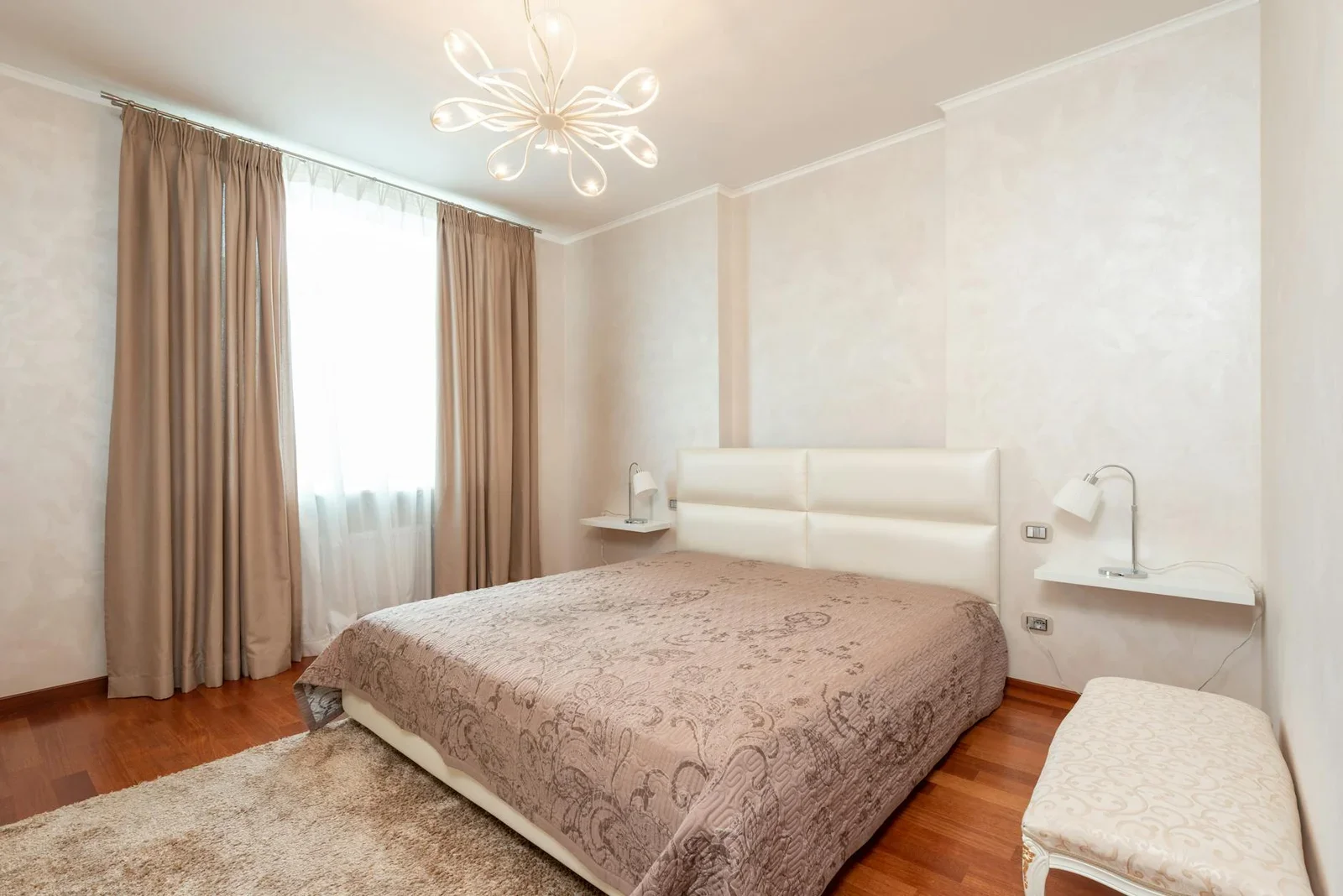 Giường ngủ êm ái phủ chăn dày trong phòng cổ điển ấm cúng, nổi bật với đèn chùm sang trọng và ánh sáng dịu nhẹ. | Thiết kế nội thất 24