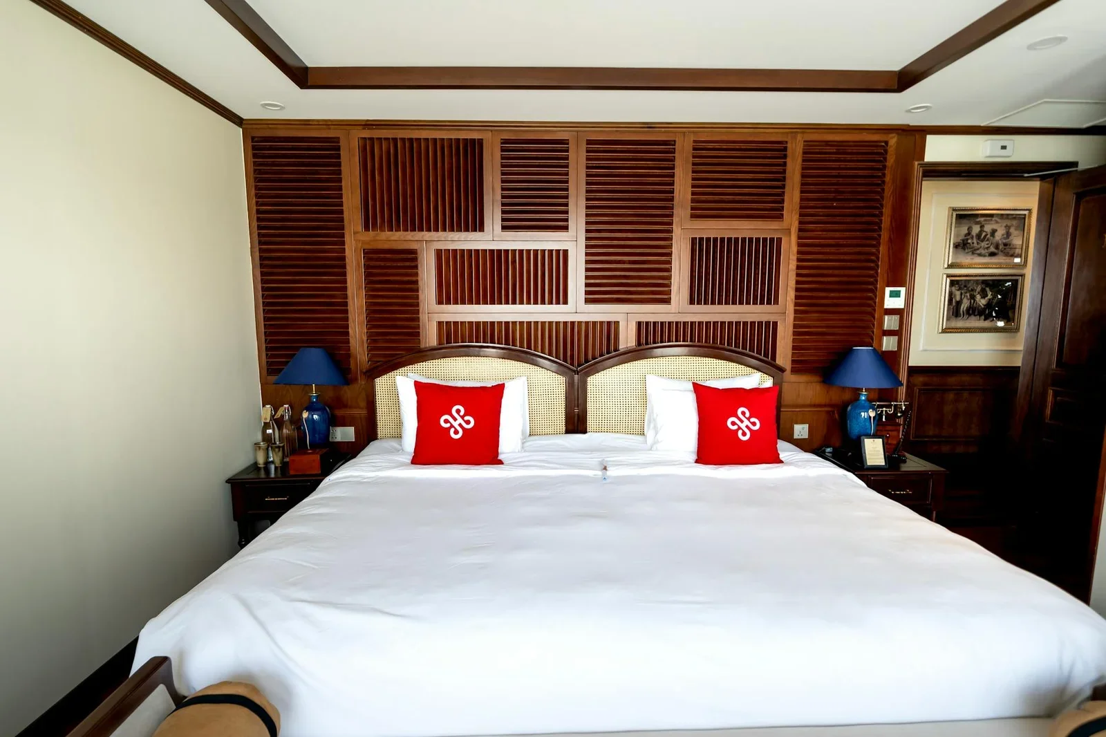 Không gian nghỉ ngơi đẳng cấp với điểm nhấn gỗ chạm khắc tỉ mỉ, bao quanh giường king size rộng rãi cho giấc ngủ trọn vẹn. | Thiết kế nội thất 24