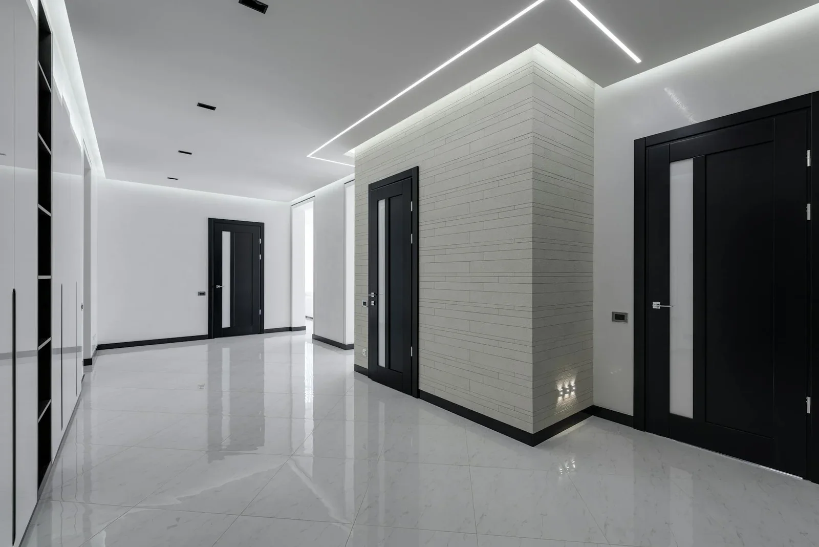 Hành lang khách sạn rộng rãi phối tông trắng đen tương phản, hệ đèn LED âm trần tạo hiệu ứng dẫn lối hiện đại. | Thiết kế nội thất 24