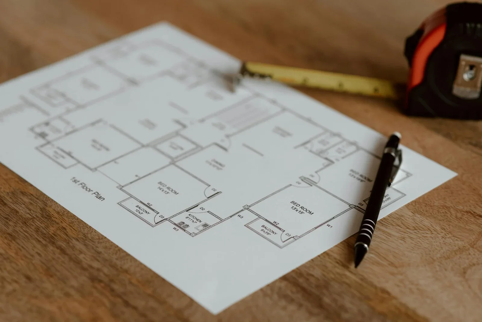 Bản vẽ mặt bằng nhà hàng trải trên bàn gỗ, cùng thước bút sẵn sàng cho quy trình thi công chính xác. | Thiết kế nội thất 24
