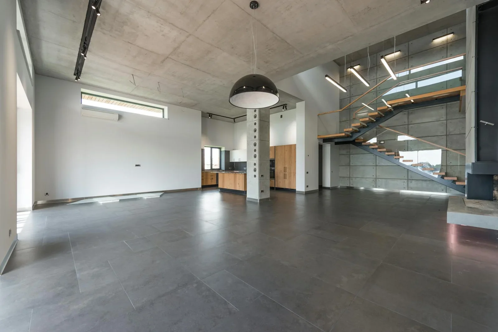 Hành lang nhà hàng phong cách loft hiện đại, sàn đá xám sang trọng cùng cầu thang tối giản tạo lối di chuyển rộng rãi. | Thiết kế nội thất 24
