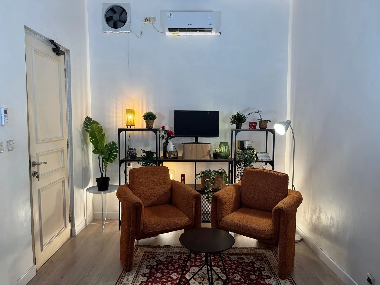 Phòng làm việc tại gia ấm cúng với ghế bành êm ái, cây xanh tươi mát và kệ tủ sắp xếp khoa học. | Thiết kế nội thất 24