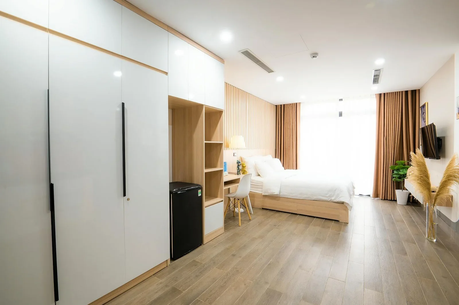 Phòng ngủ tối giản nổi bật với nội thất gỗ ấm cúng và ánh sáng tràn ngập, mang đến không gian nghỉ ngơi thư thái. | Thiết kế nội thất 24