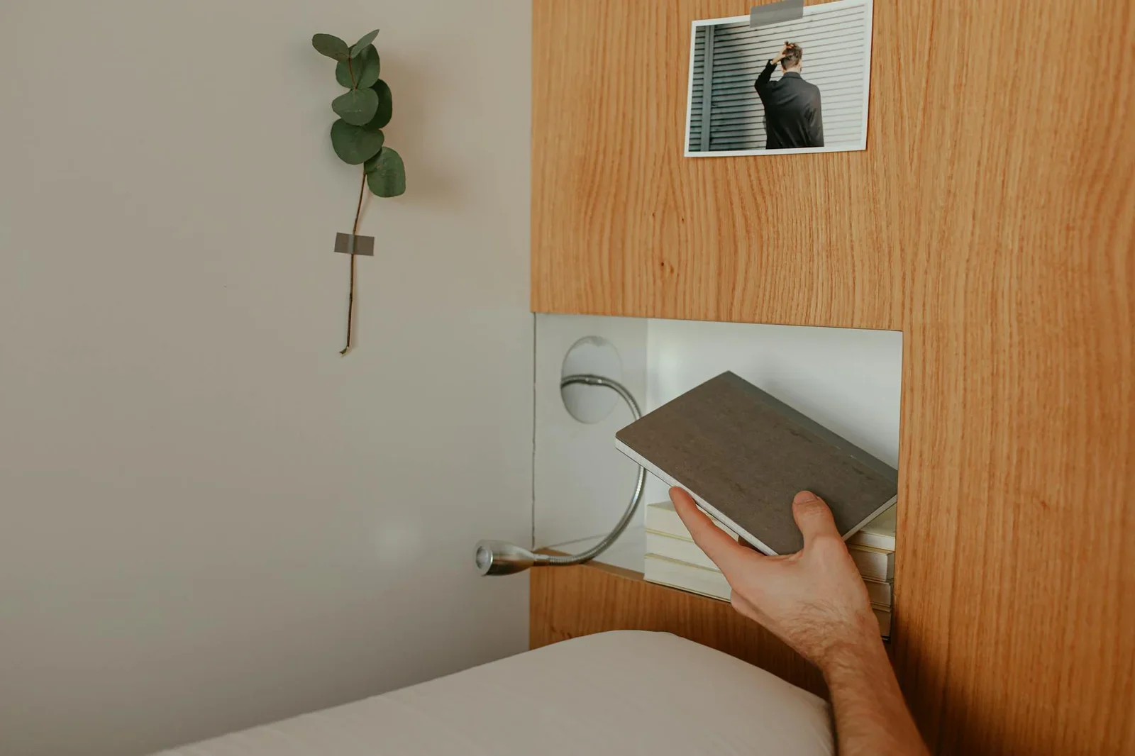 Bàn tay nhẹ nhàng đặt cuốn sách lên kệ gỗ trơn láng kết hợp phụ kiện trang trí tinh tế. | Thiết kế nội thất 24