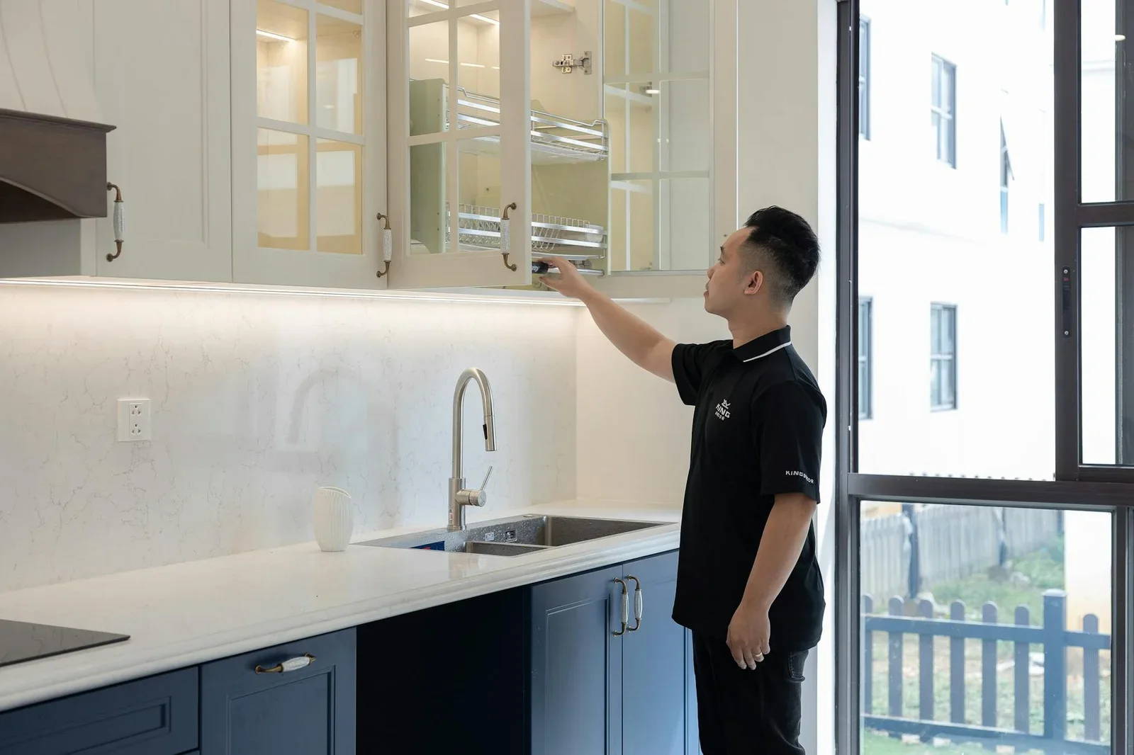 Tay người sắp xếp hệ tủ bếp hiện đại thiết kế thanh lịch dưới nguồn sáng rực rỡ tạo sự ngăn nắp. | Thiết kế nội thất 24
