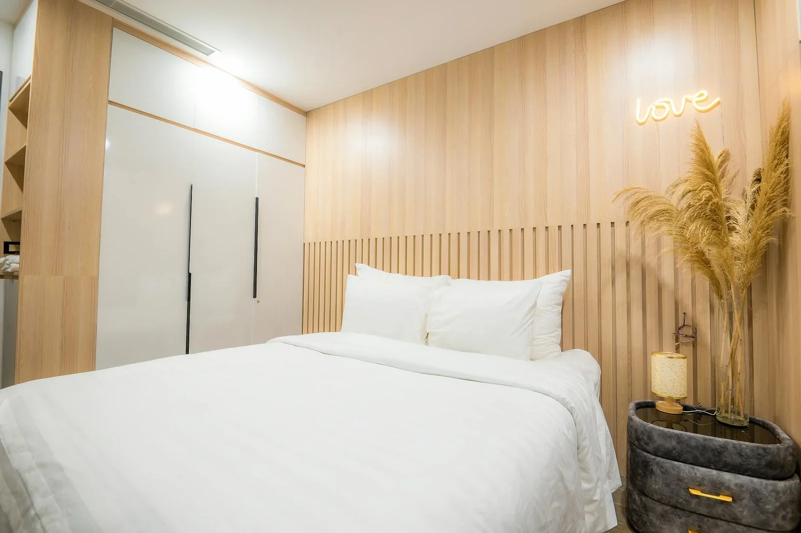 Không gian nghỉ ngơi tối giản điểm xuyết chi tiết gỗ cùng ánh sáng vàng nhẹ mang lại cảm giác thư giãn. | Thiết kế nội thất 24