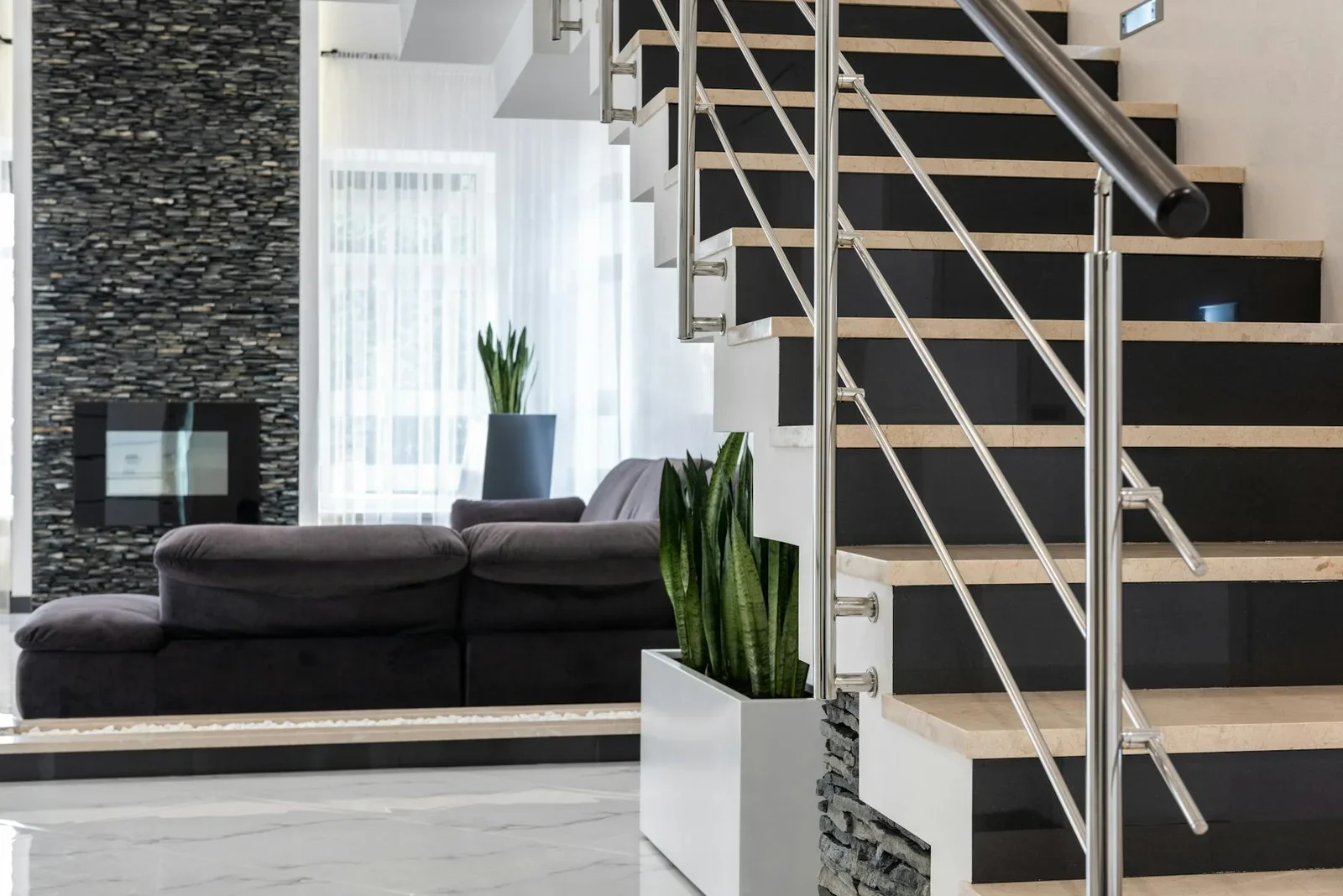Phòng khách rộng rãi bài trí sofa êm ái, điểm nhấn cầu thang xanh mát với chậu cây sáng tạo đầy sức sống. | Thiết kế nội thất 24