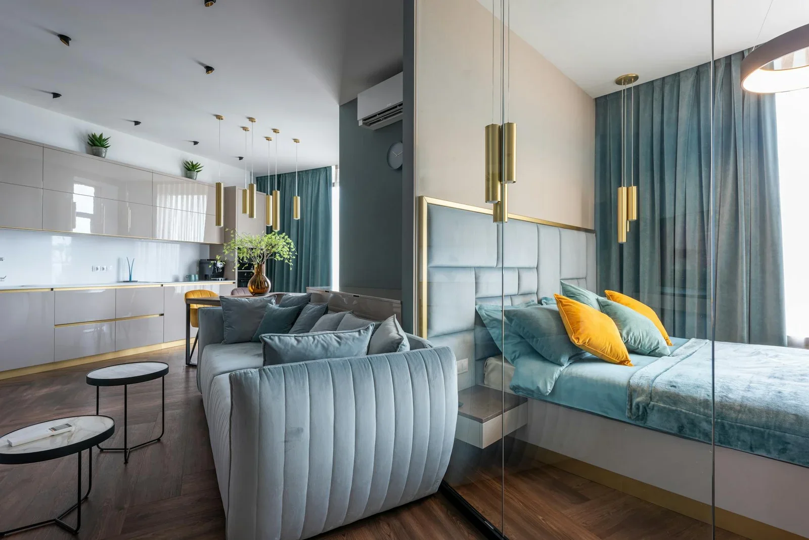 Không gian mở hiện đại với tủ bếp tiện nghi, ghế sofa mềm mại và vách kính ngăn phòng ngủ thoáng đãng. | Thiết kế nội thất 24