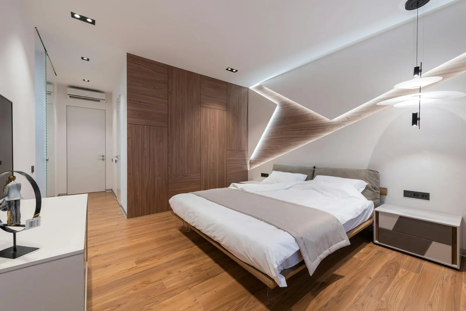 Phòng ngủ hiện đại phong cách khách sạn với giường trắng êm ái, sàn gỗ tự nhiên và tủ lưu trữ gọn gàng. | Thiết kế nội thất 24