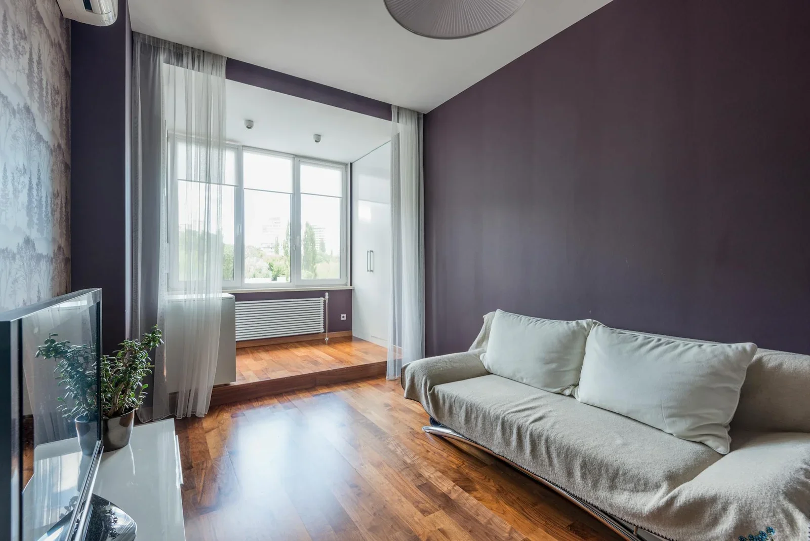 Phòng khách tinh tế với sofa êm ái và sàn gỗ ấm áp, tạo không gian sinh hoạt lý tưởng cho căn hộ nhỏ. | Thiết kế nội thất 24