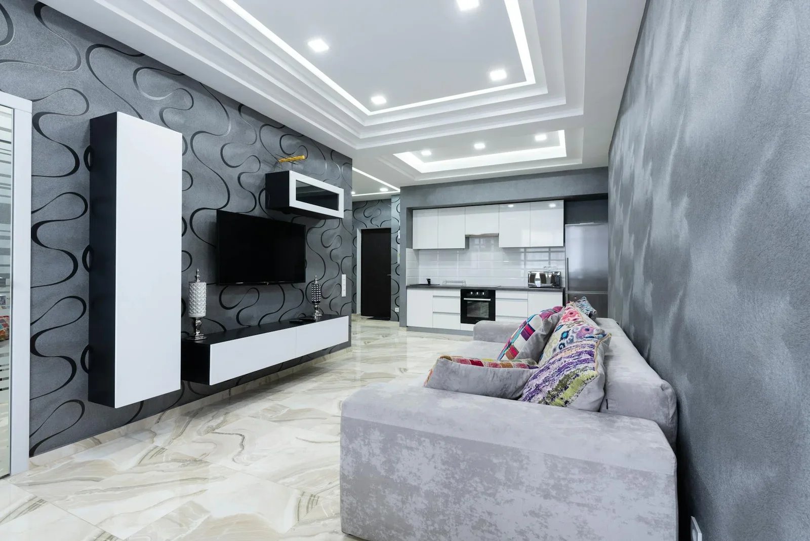 Phòng khách sang trọng nổi bật với tường xám trung tính, ghế sofa êm ái cùng gối tựa sắc màu tạo điểm nhấn ấm cúng. | Thiết kế nội thất 24
