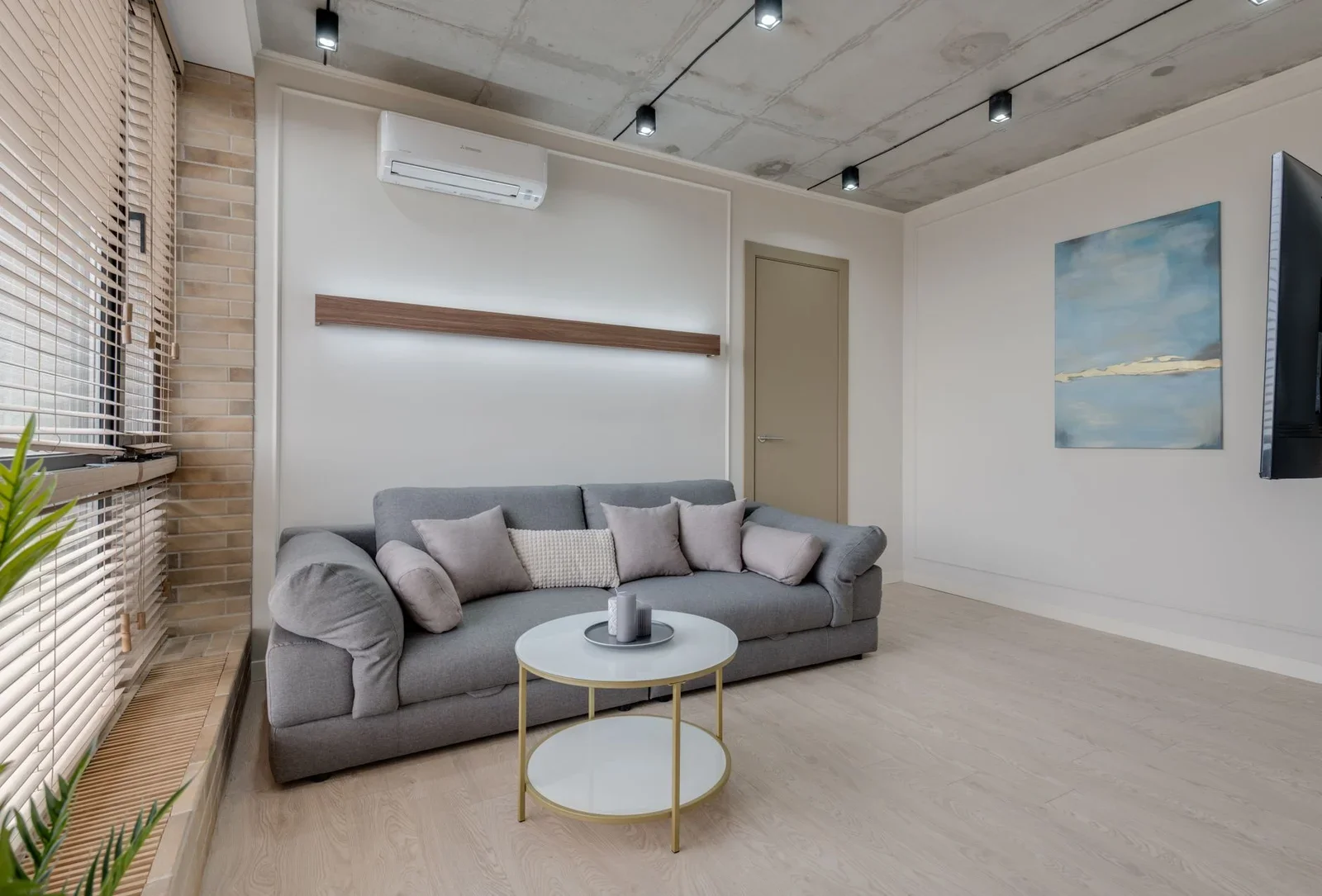 Phòng khách tối giản với ghế sofa xám, tranh trừu tượng nghệ thuật và bố cục tinh tế, tạo không gian thư giãn lý tưởng. | Thiết kế nội thất 24
