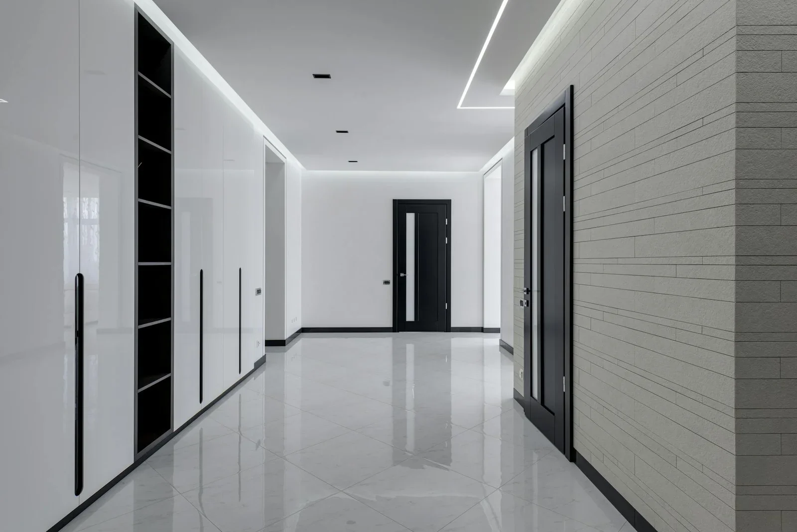 Hành lang rộng ốp gạch trắng, phối cửa gỗ đen cùng kệ âm tường, mang đến giải pháp lưu trữ thông minh cho căn hộ. | Thiết kế nội thất 24