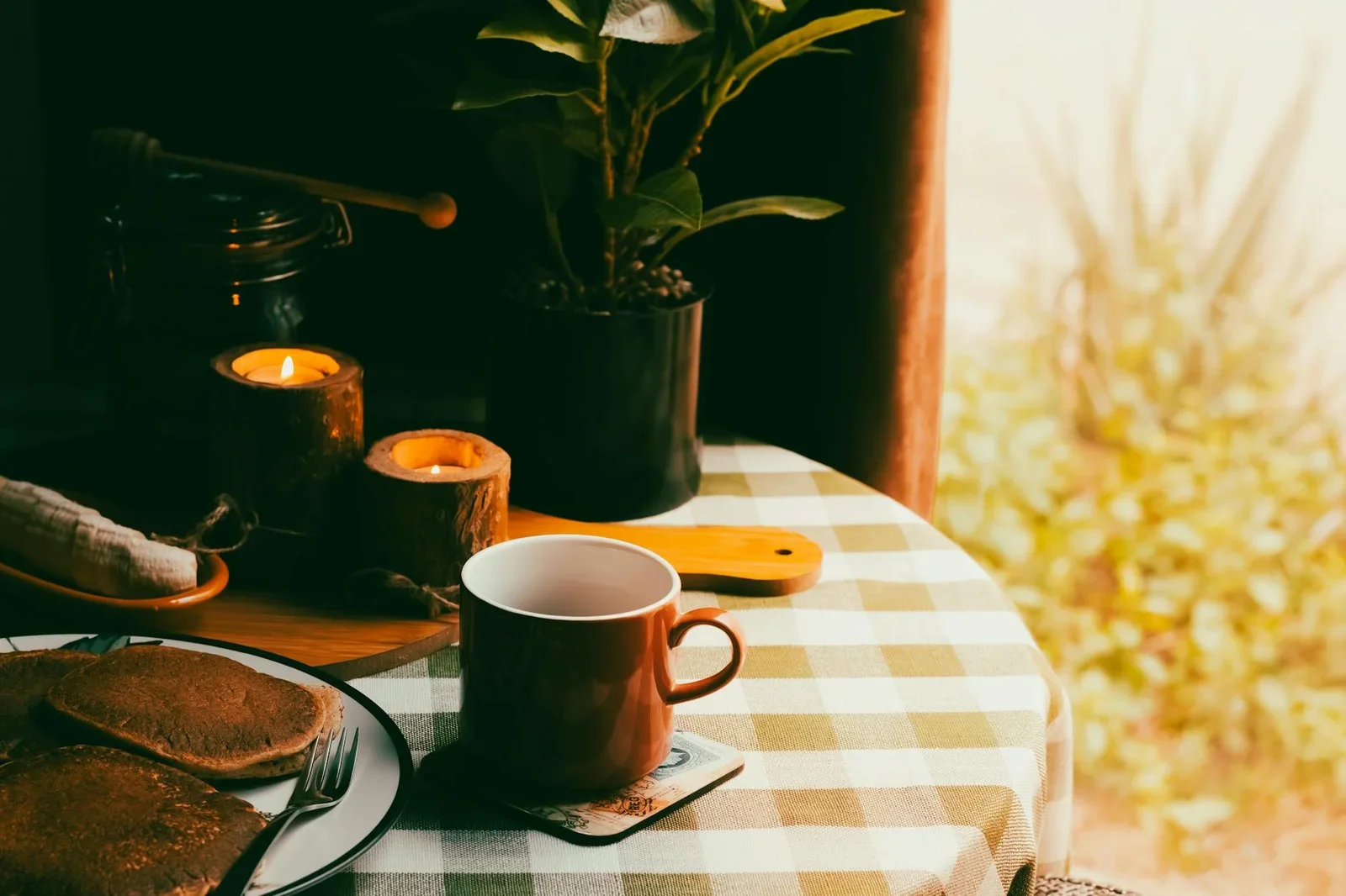 Góc ăn sáng ấm cúng với khăn caro, nến thơm, cà phê và bánh pancake, gợi ý bài trí không gian bếp nhà cấp bốn. | Thiết kế nội thất 24