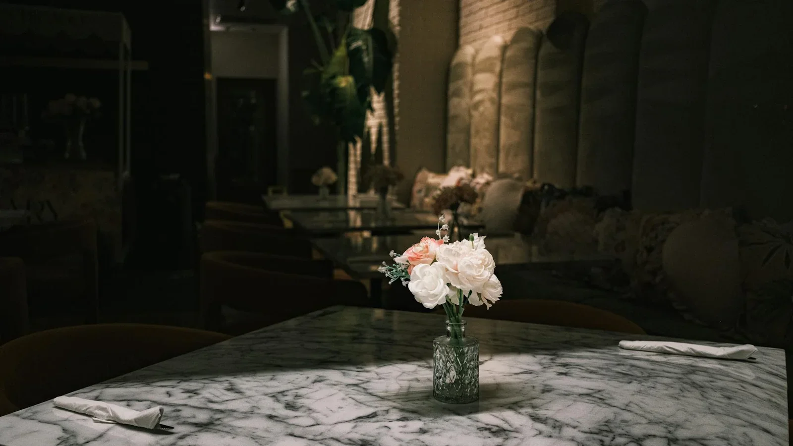 Bàn đá marble sang trọng cùng lọ hoa tươi dưới ánh sáng dịu nhẹ, kiến tạo không gian quán cafe ấm cúng và đầy đẳng cấp. | Thiết kế nội thất 24