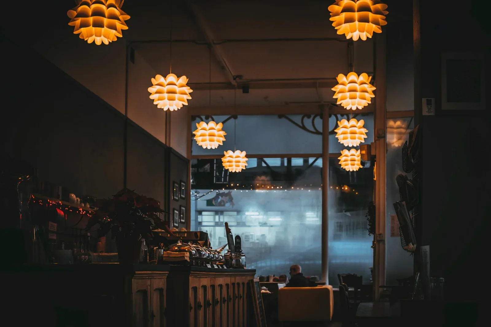 Ánh sáng vàng ấm áp cùng đèn thả trần tinh tế, kiến tạo không gian quán cafe thân thiện và mang lại cảm giác thư giãn. | Thiết kế nội thất 24