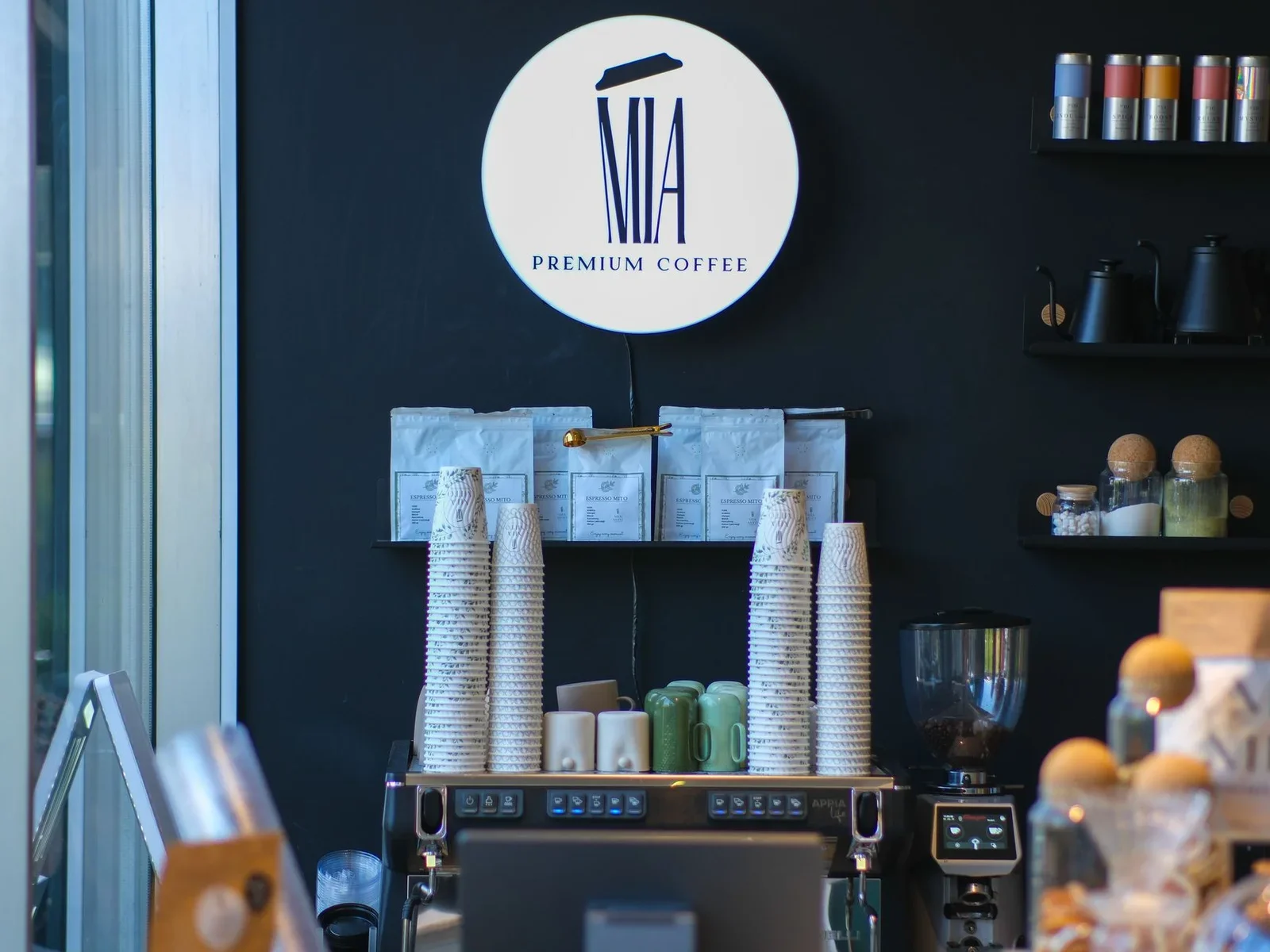 Không gian quán cafe phong cách với khu trưng bày dụng cụ và ly tách gọn gàng, tôn vinh sự chuyên nghiệp trong từng chi tiết. | Thiết kế nội thất 24