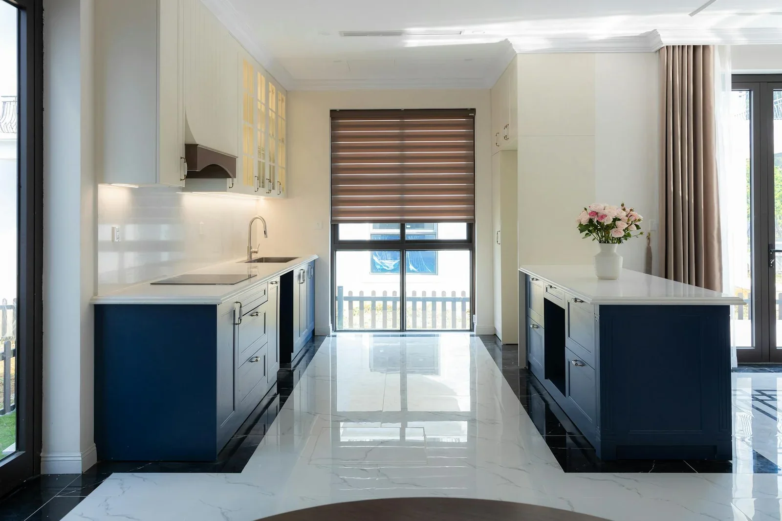 Không gian bếp sang trọng với hệ tủ xanh dương cùng sàn đá cẩm thạch, tạo điểm nhấn cho shophouse hiện đại. | Thiết kế nội thất 24