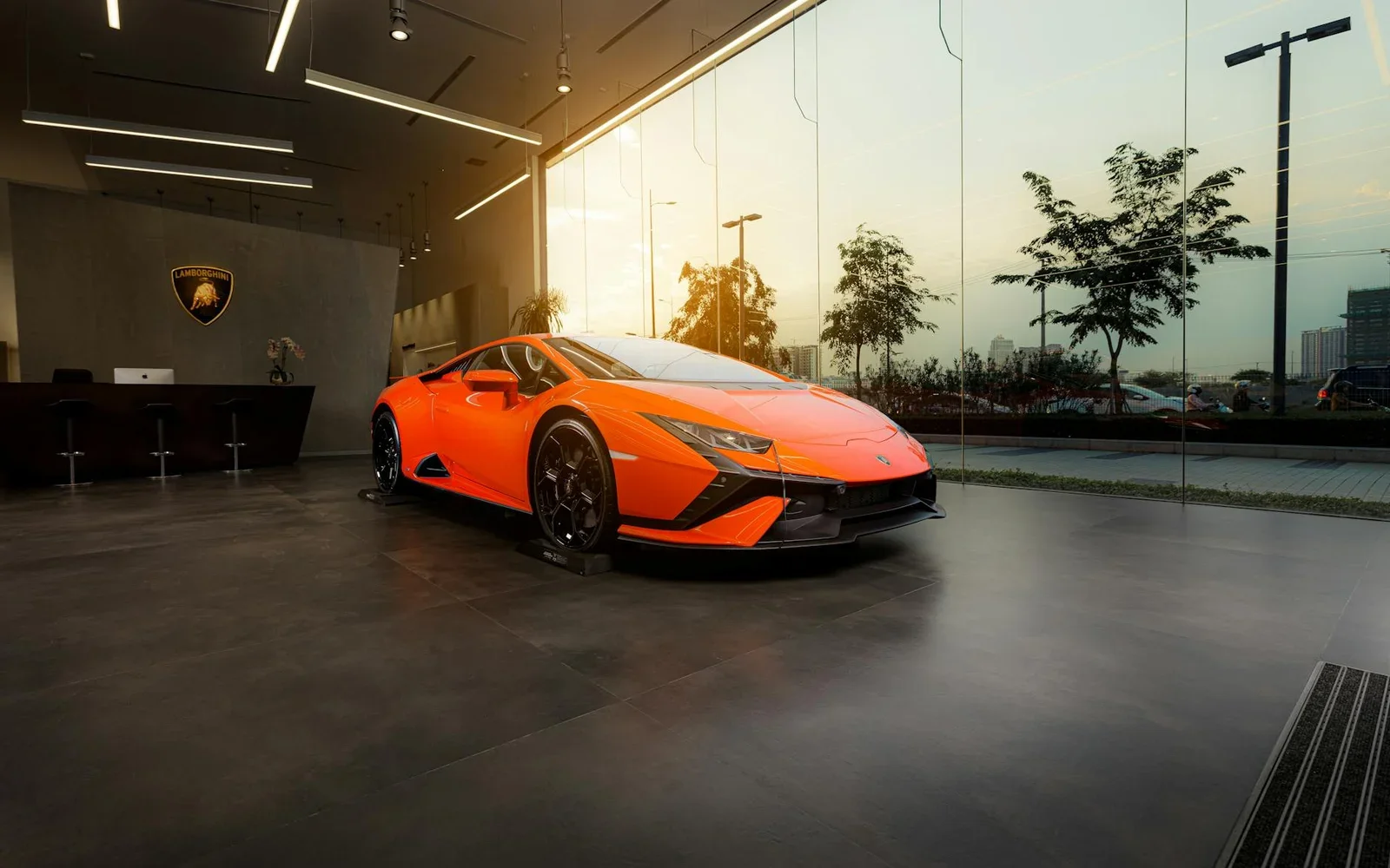 Showroom ô tô hiện đại với thiết kế tối giản, ánh sáng chuyên nghiệp tôn vinh siêu xe màu cam nổi bật. | Thiết kế nội thất 24