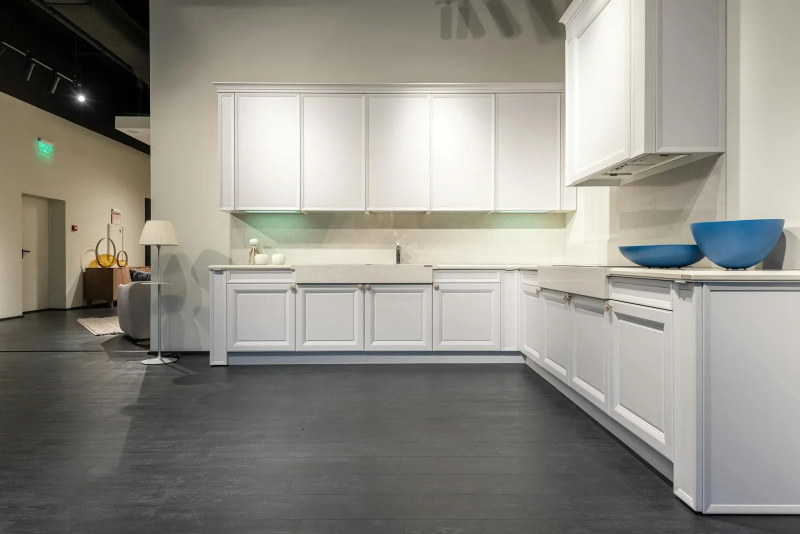 Hệ tủ bếp trắng tinh tế bố trí khoa học trong showroom rộng rãi, mang đến vẻ đẹp hiện đại và tiện nghi. | Thiết kế nội thất 24