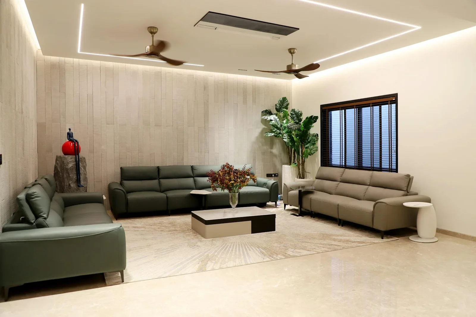 Phòng khách rộng rãi phong cách tối giản với sofa xanh, cây nội thất và decor tinh tế, mang lại sự thoáng đãng. | Thiết kế nội thất 24
