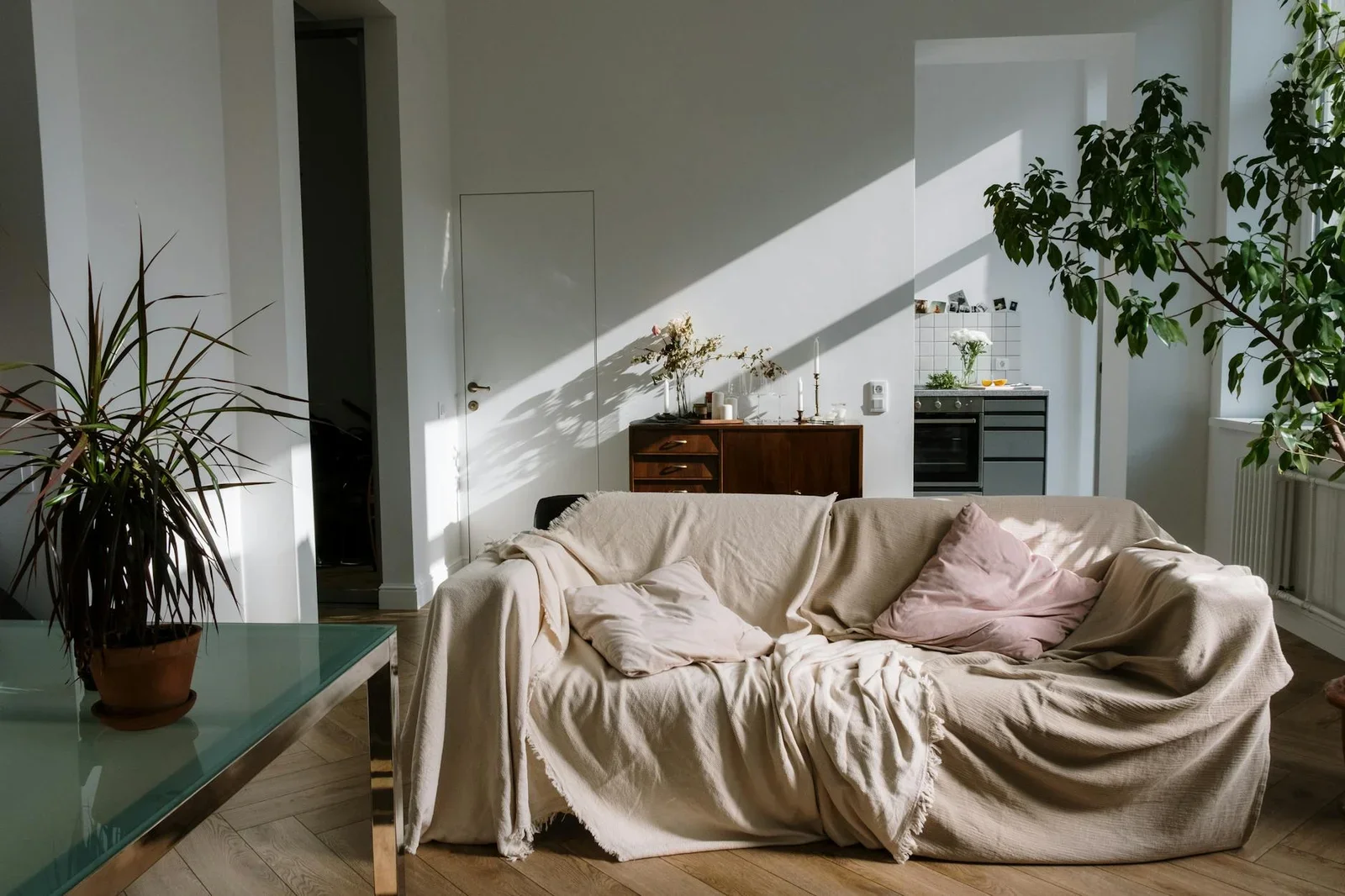 Căn hộ ấm áp đón nắng tự nhiên với sofa màu be, chậu cây xanh và decor tông ấm tạo cảm giác thân thuộc. | Thiết kế nội thất 24