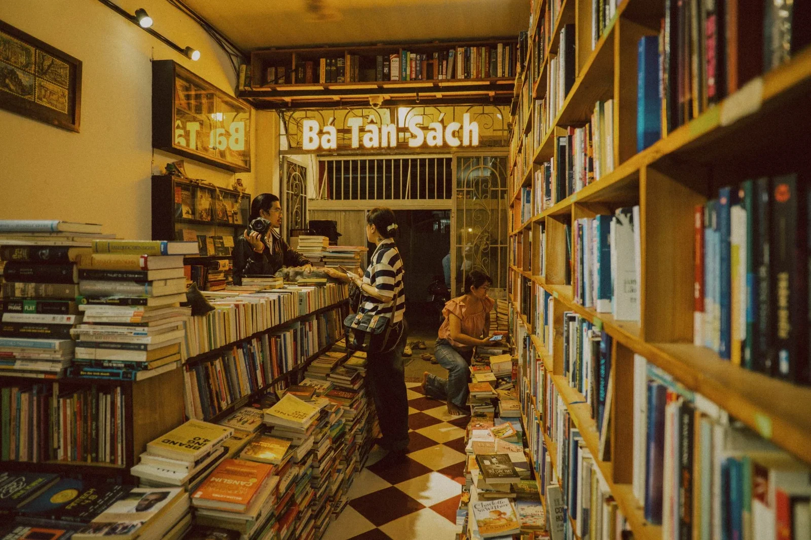 Warm, inviting bookstore with customers browsing books in a | Thiết kế nội thất 24