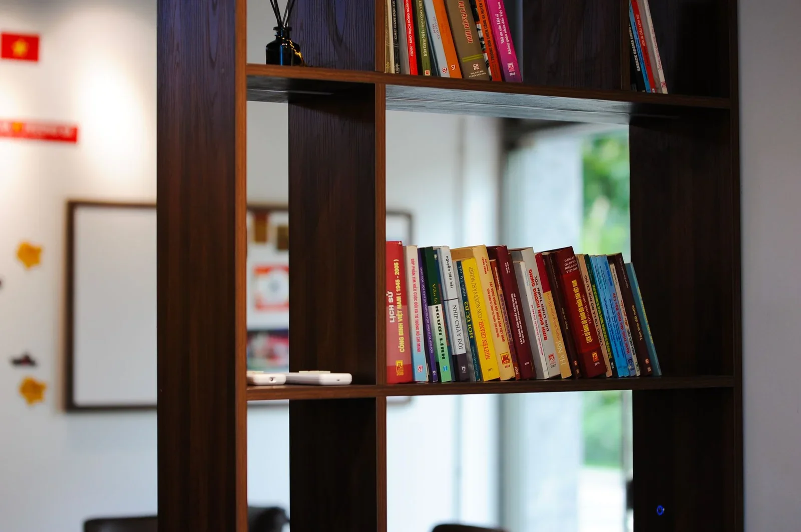 A bookshelf filled with colorful Vietnamese books in a moder | Thiết kế nội thất 24