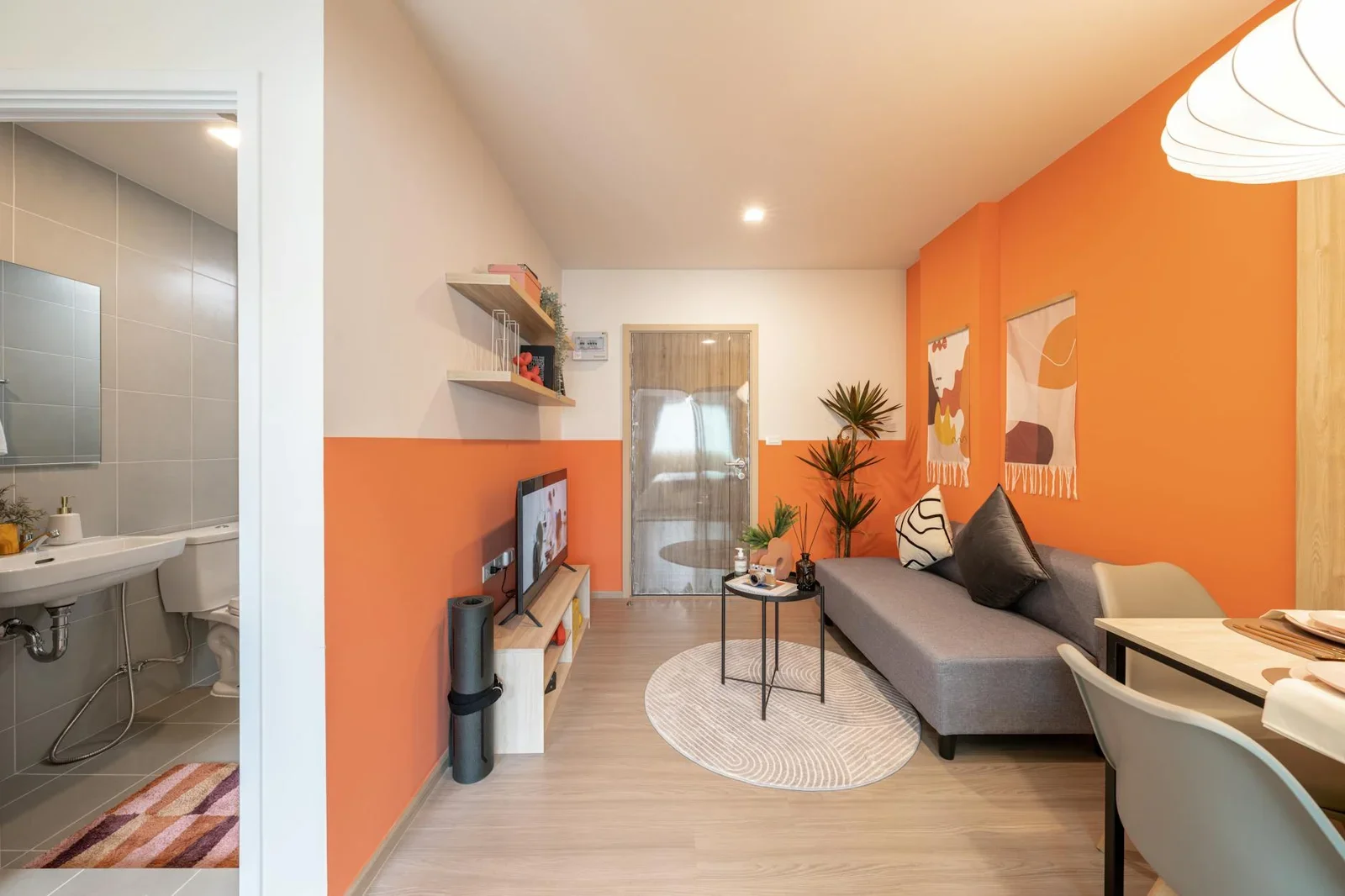 Phòng khách hiện đại nổi bật với tường cam ấm áp, decor tinh tế cùng ánh sáng tự nhiên lan tỏa khắp không gian. | Thiết kế nội thất 24