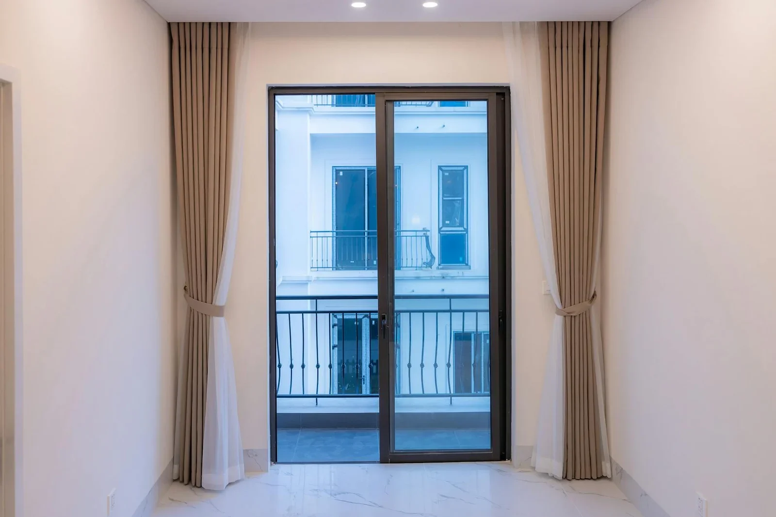 Cửa kính trượt lớn cùng rèm vải sang trọng đón ánh sáng tự nhiên, giúp không gian nhỏ luôn thông thoáng và mở rộng tầm nhìn. | Thiết kế nội thất 24