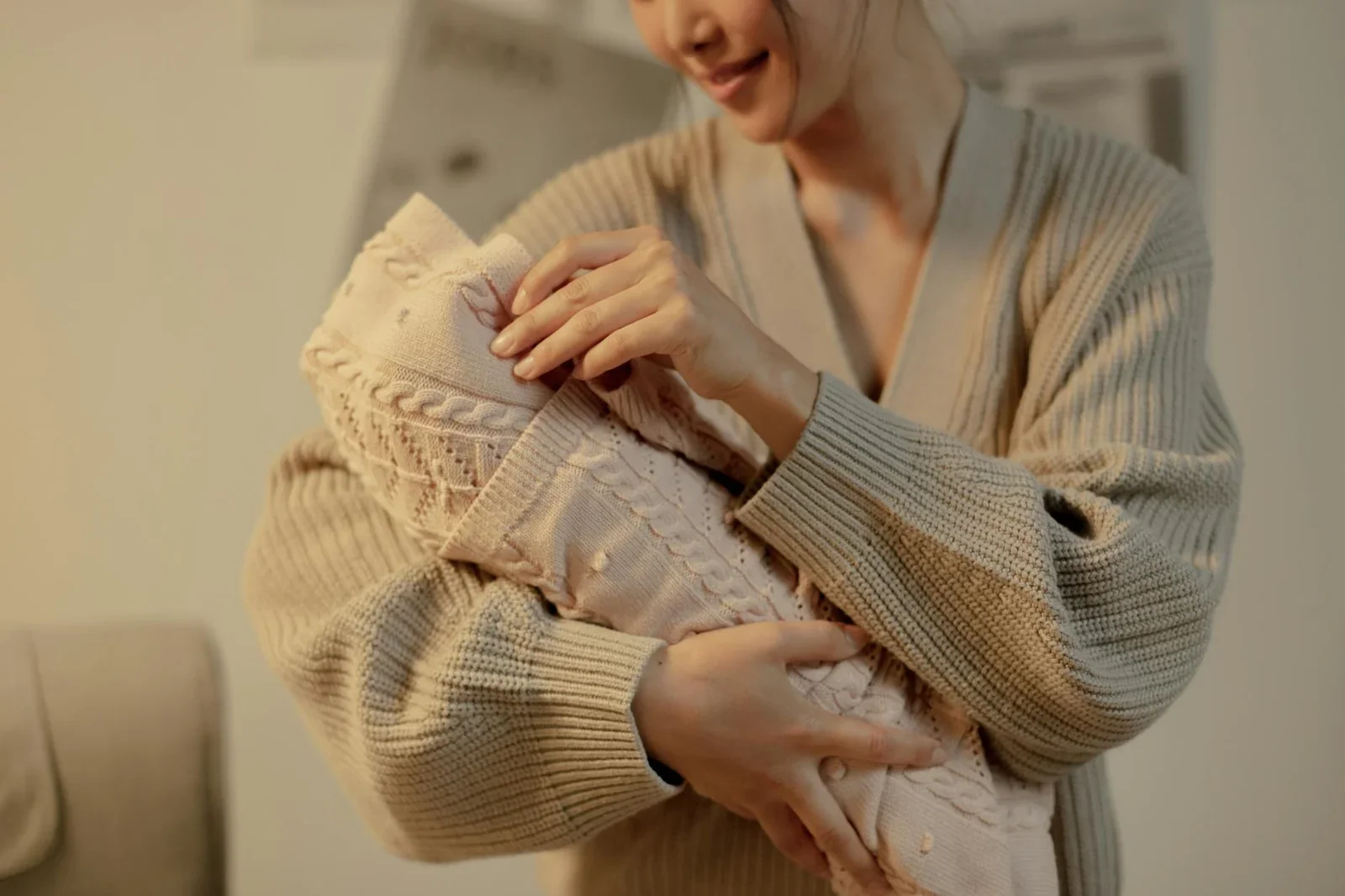 Mẹ ôm bé trong chăn len mềm mại, lan tỏa sự ấm áp, gợi cách phối chất liệu êm ái cho góc làm việc. | Thiết kế nội thất 24