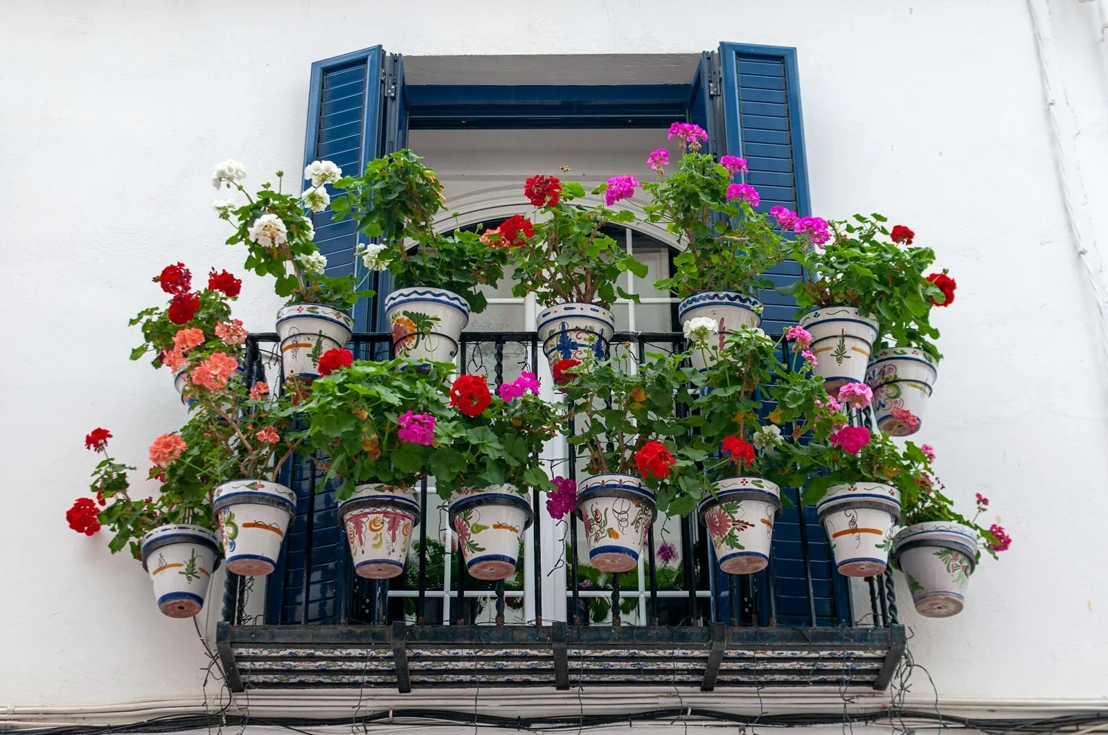 Vibrant geraniums adorn a balcony in Sitges, Spain, creating | Thiết kế nội thất 24
