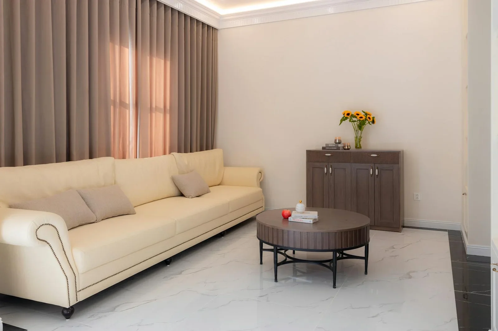 Ghế sofa màu kem trang nhã kết hợp hoa hướng dương rực rỡ tạo điểm nhấn tươi mới, thổi bừng sức sống cho phòng khách. | Thiết kế nội thất 24