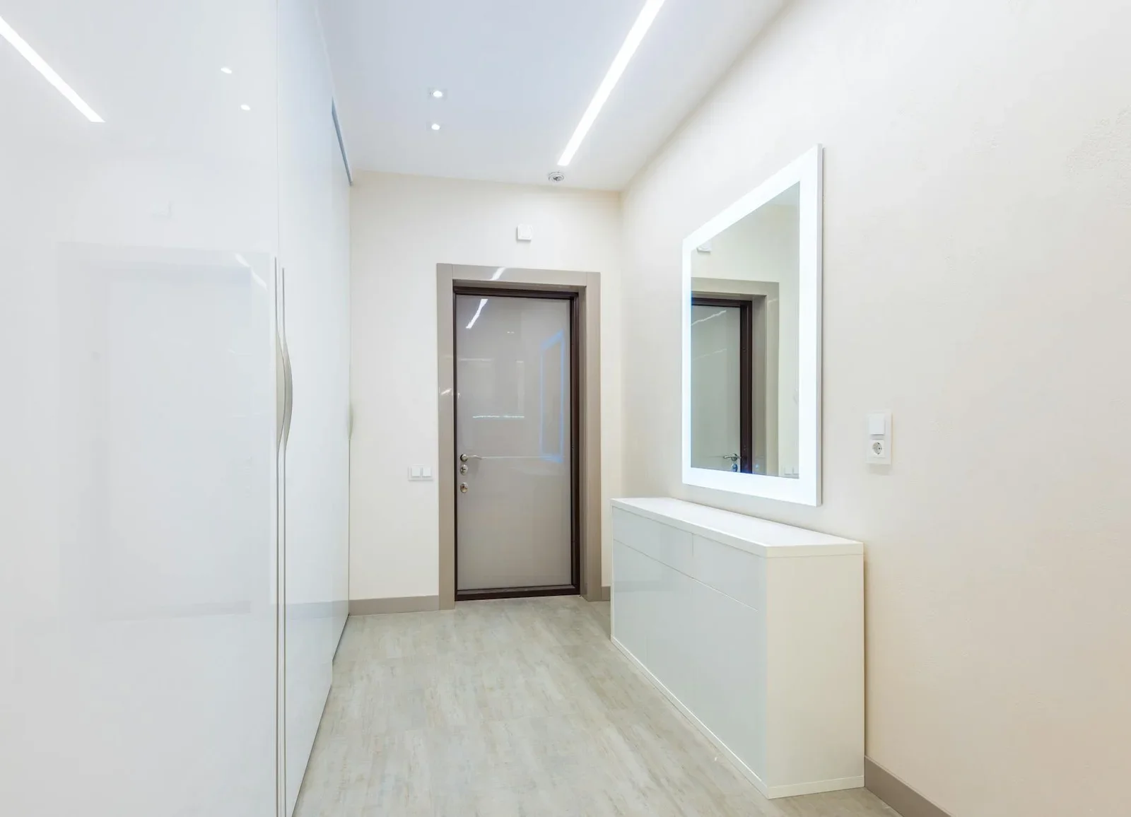 Hành lang tối giản với tủ áo cao trần, cửa kính khung gỗ và kệ trắng kết hợp gương led tạo điểm nhấn. | Thiết kế nội thất 24