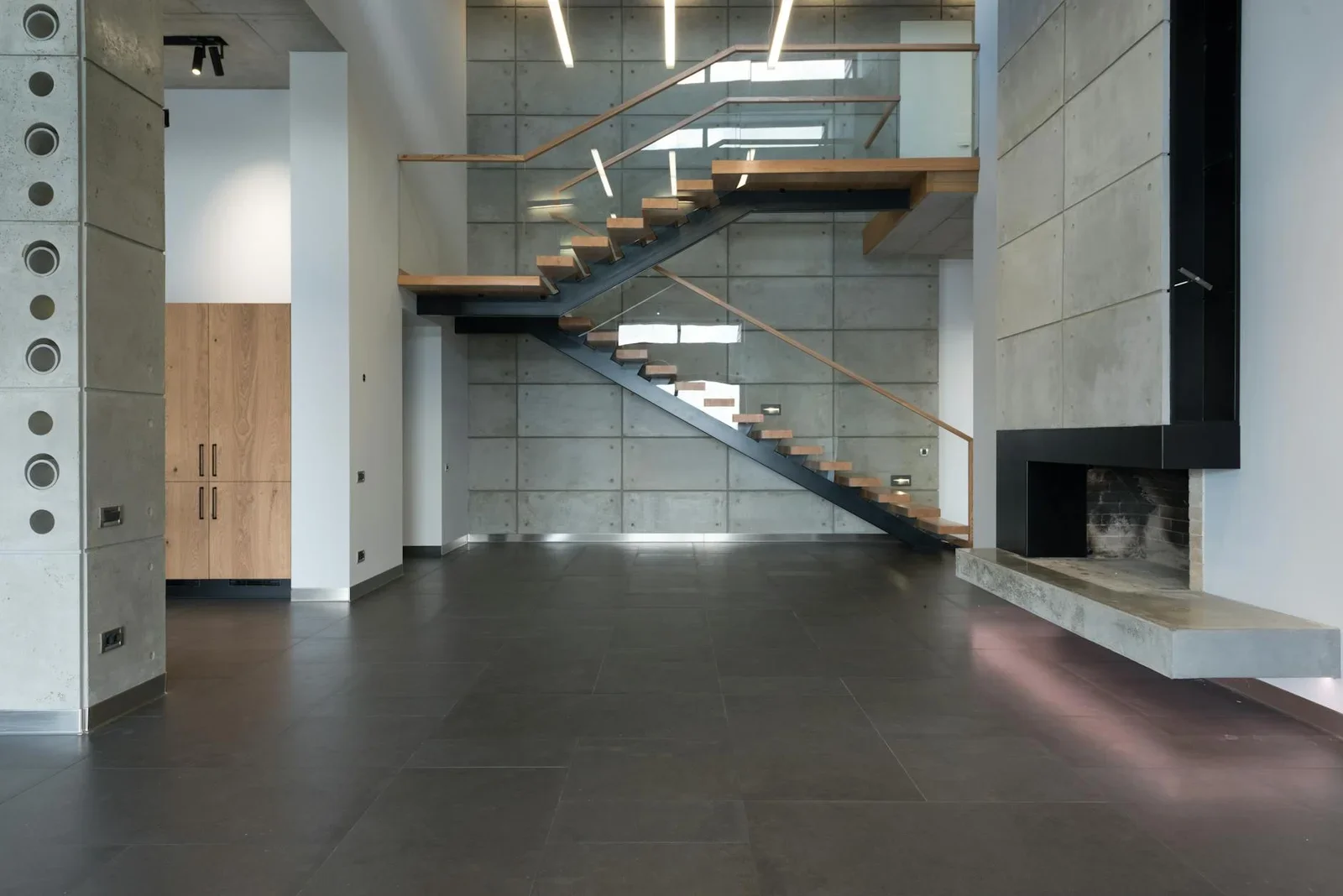 Thi công nội thất Duplex rộng rãi lát gạch sáng màu, nổi bật với cầu thang gỗ dẫn lên tầng hai, tối ưu diện tích sống. | Thiết kế nội thất 24