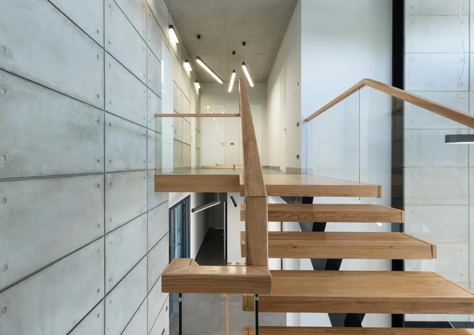 Phong cách loft đương đại nổi bật với bậc thang gỗ cùng lan can kính trong suốt, dẫn lối lên tầng hai mở rộng tầm nhìn. | Thiết kế nội thất 24