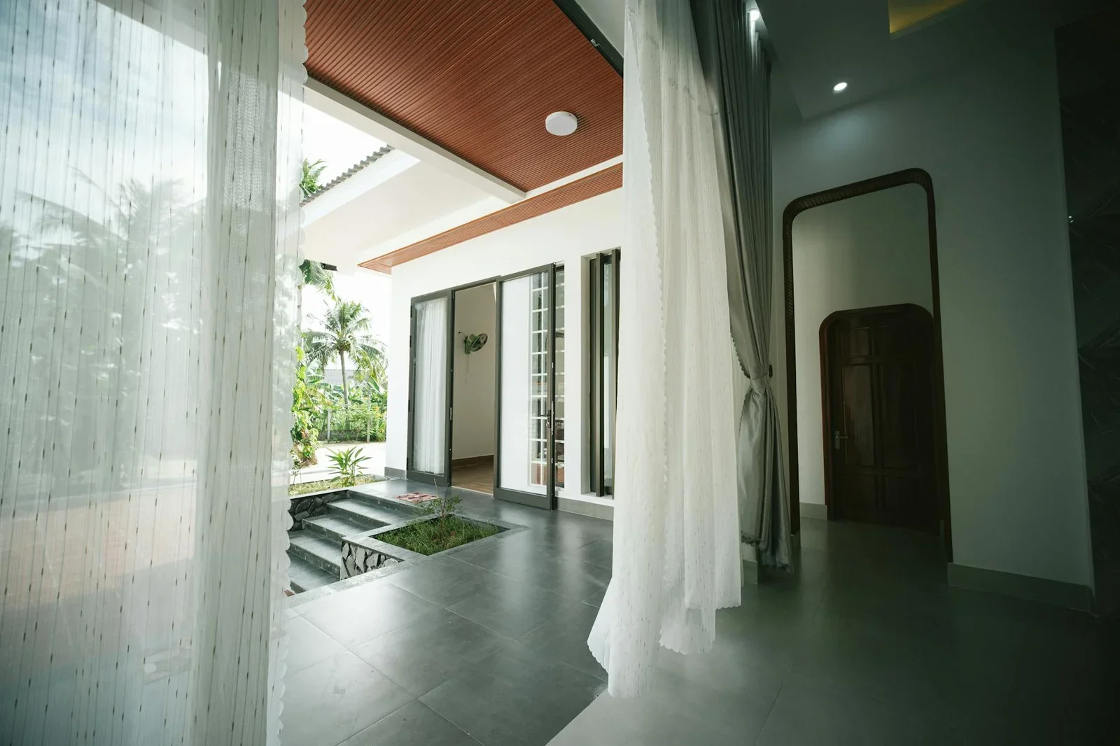 Nội thất rộng rãi kết hợp sân mở với cây nhiệt đới và ánh sáng tự nhiên, kiến tạo không gian sống xanh lý tưởng. | Thiết kế nội thất 24