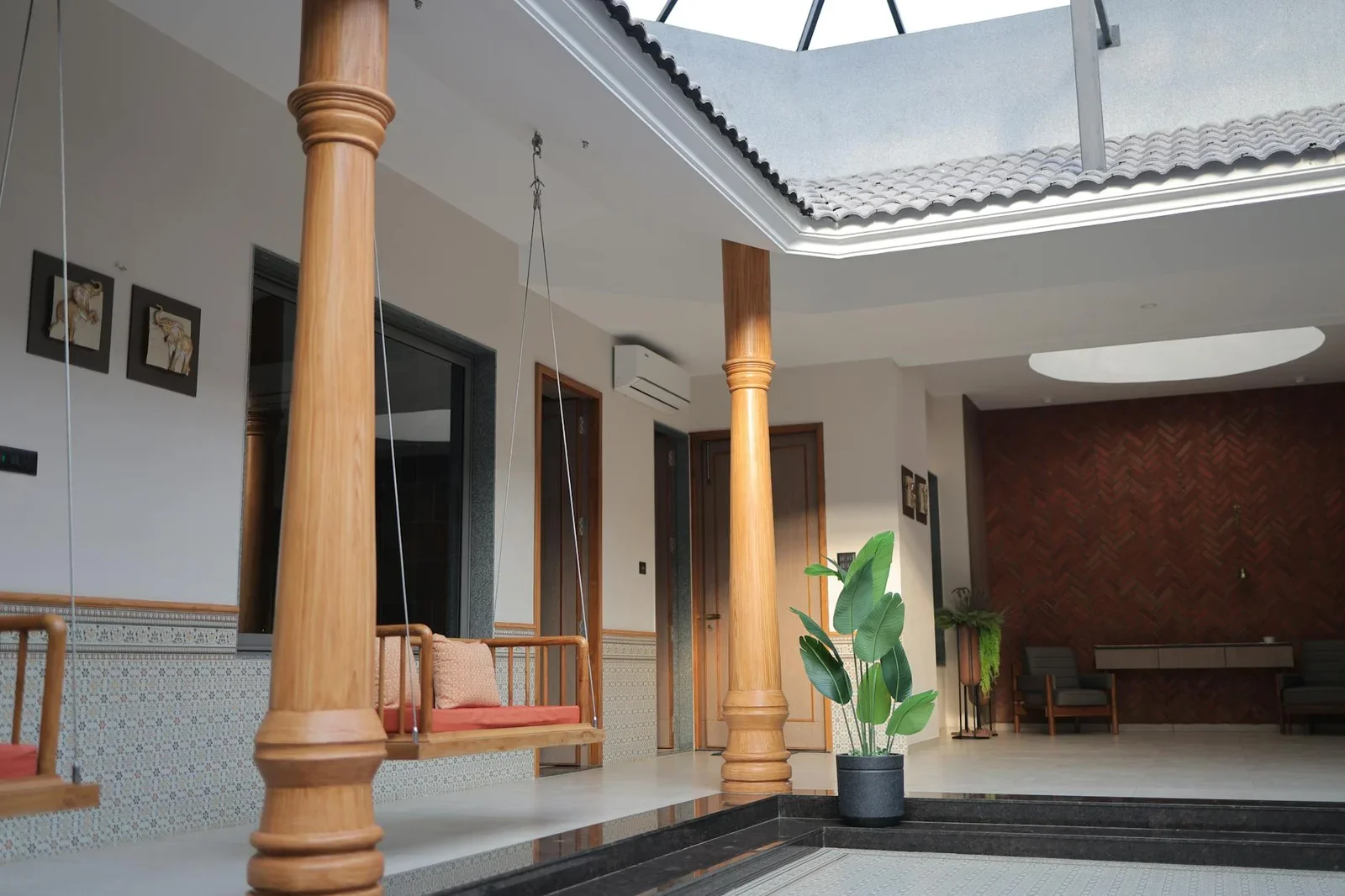 Giếng trời trong nhà thoáng đãng với xích đu gỗ mộc mạc, ánh sáng tự nhiên và đồ trang trí hiện đại tinh tế. | Thiết kế nội thất 24