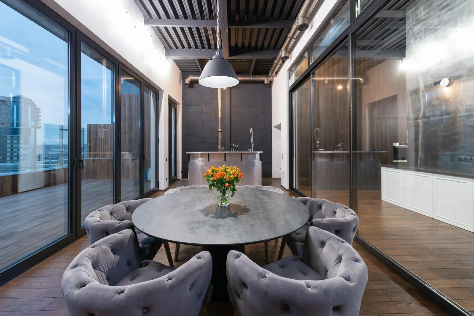 Khu lounge hiện đại với bàn tròn và ghế bành êm ái, đặt cạnh cửa kính lớn đón ánh hoàng hôn lãng mạn buổi chiều. | Thiết kế nội thất 24