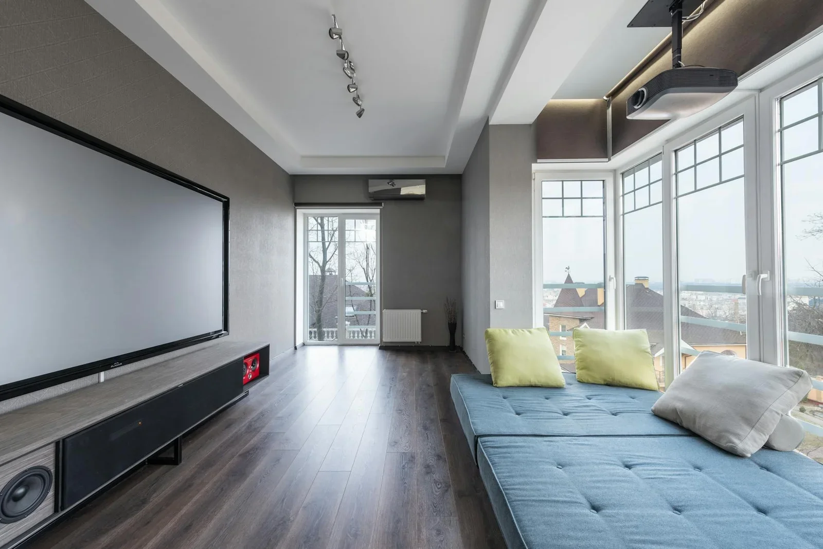 Phòng khách thoáng đãng với sofa đệm màu nổi bật, cửa kính lớn và tivi hiện đại, kiến tạo không gian sinh hoạt lý tưởng. | Thiết kế nội thất 24