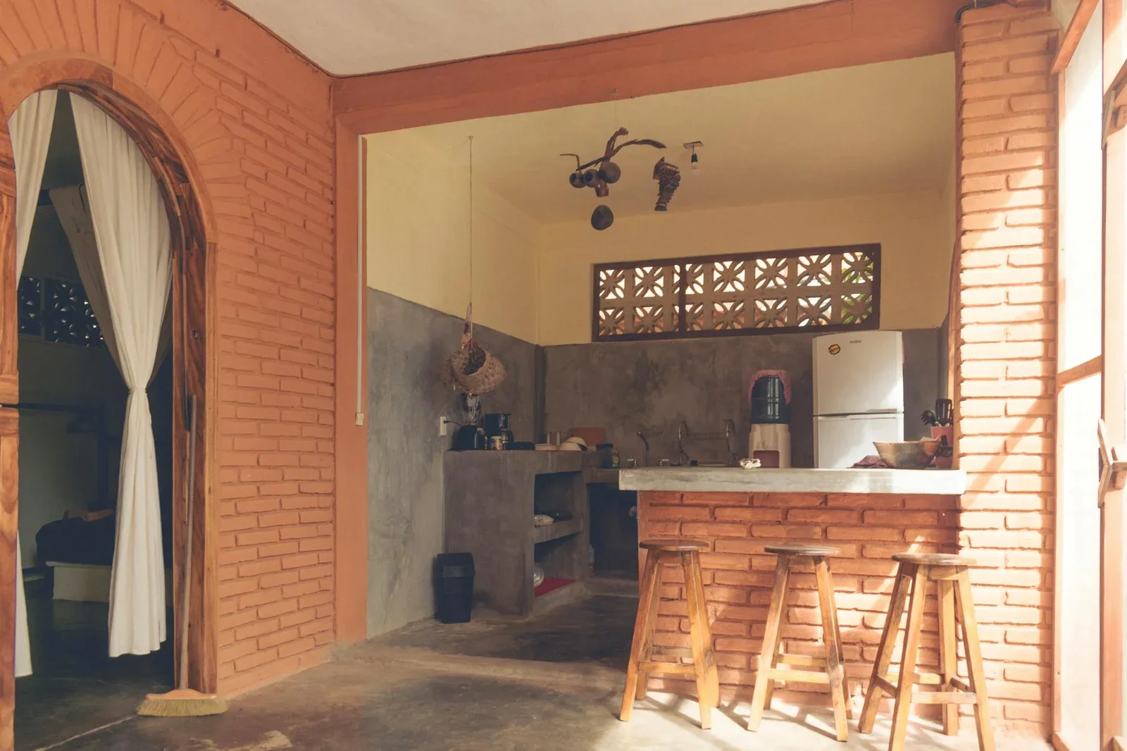 Thiết kế bếp mộc mạc với tường gạch trần, ghế quầy bar gỗ và ánh sáng vàng ấm áp mang lại cảm giác thư thái. | Thiết kế nội thất 24