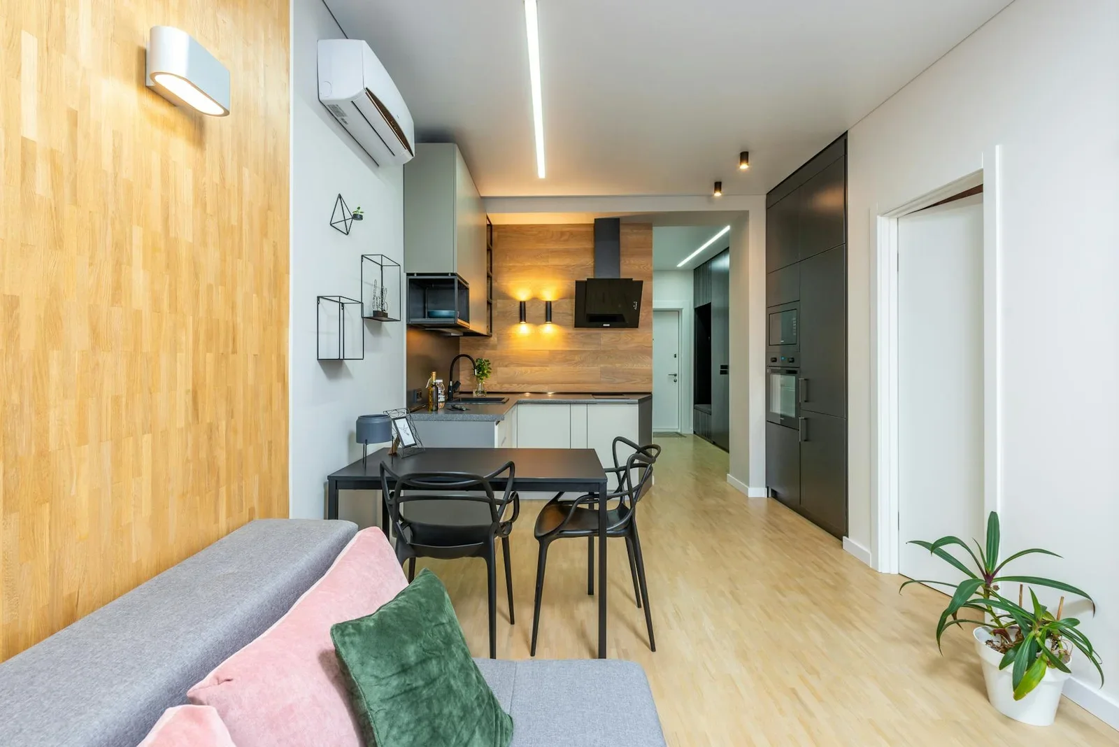 Không gian bếp mở rộng rãi với ghế sofa êm ái, bàn ăn hiện đại cùng chậu cây xanh tạo điểm nhấn sinh động. | Thiết kế nội thất 24