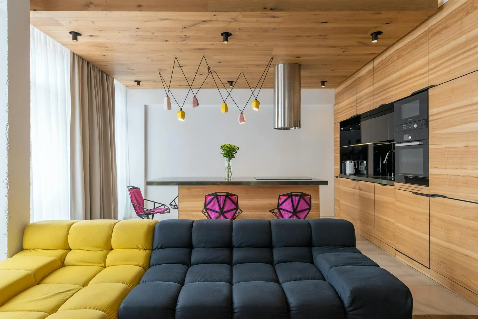 Ghế sofa sắc màu kết hợp bàn ăn và bếp hiện đại trong căn hộ studio, kiến tạo phòng khách đa năng tiện nghi và trẻ trung. | Thiết kế nội thất 24