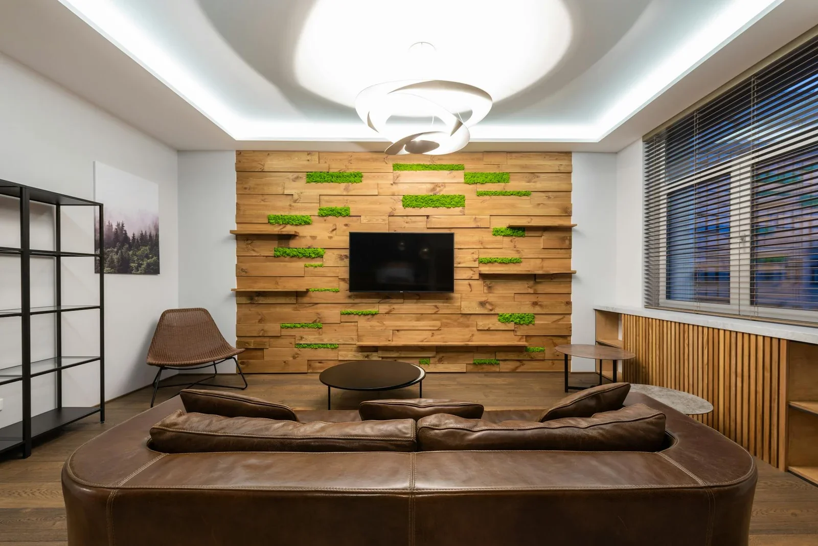Phòng khách hiện đại với kệ trang trí tối giản, sofa da nâu rộng rãi và đèn hình học tỏa sáng, tạo điểm nhấn nghệ thuật độc đáo. | Thiết kế nội thất 24