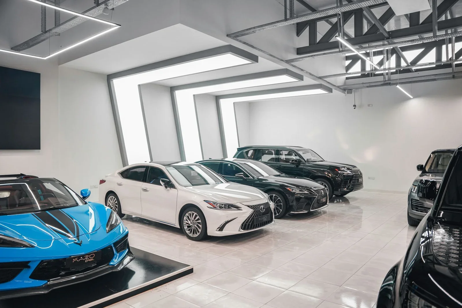 Không gian showroom ô tô hiện đại thiết kế mở, ánh sáng đồng đều làm nổi bật vẻ đẹp sang trọng của các mẫu xe cao cấp. | Thiết kế nội thất 24
