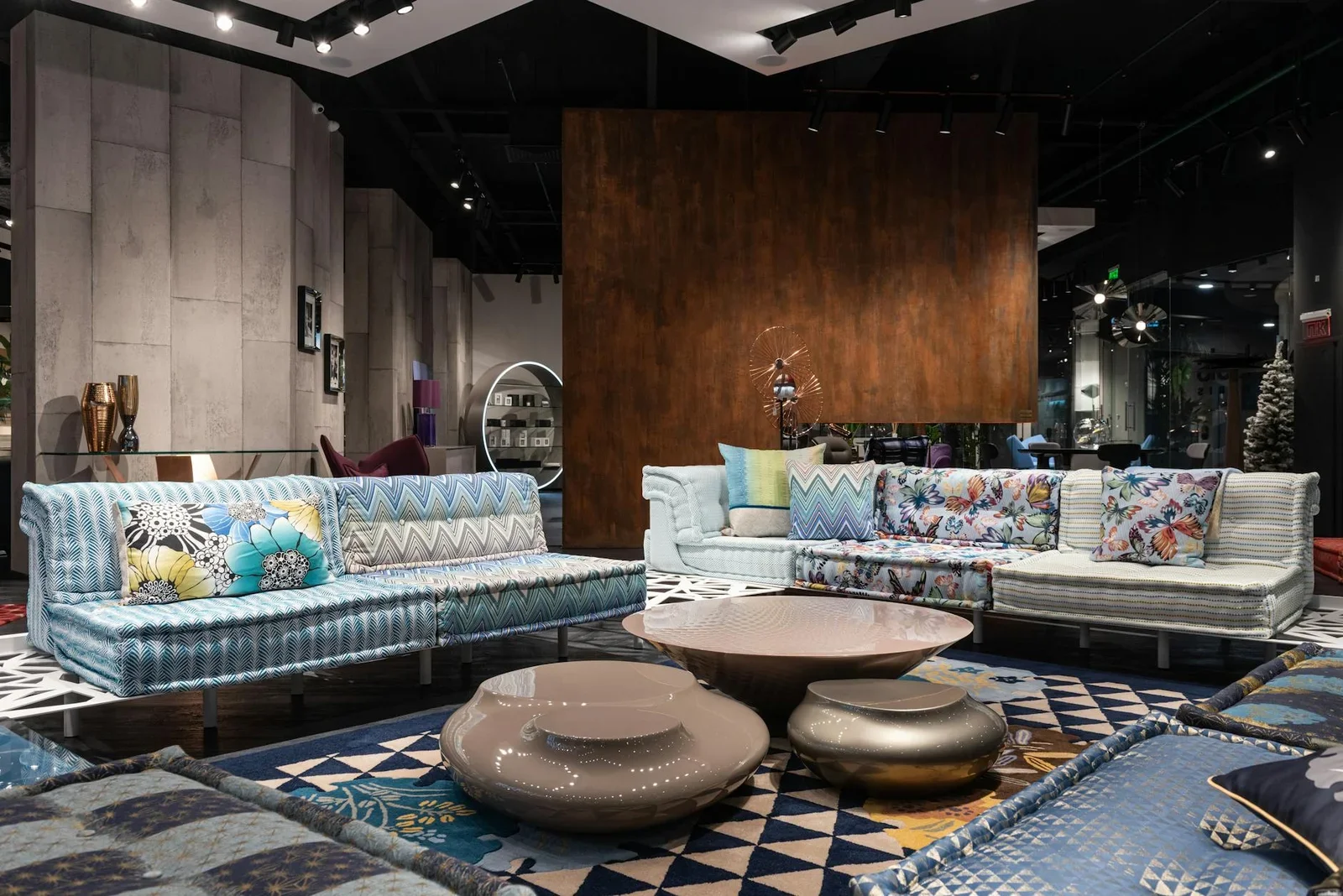 Khu trưng bày phòng khách rộng rãi với sofa êm ái, gối đa sắc cùng bàn trà sáng tạo đặt trên thảm hiện đại. | Thiết kế nội thất 24