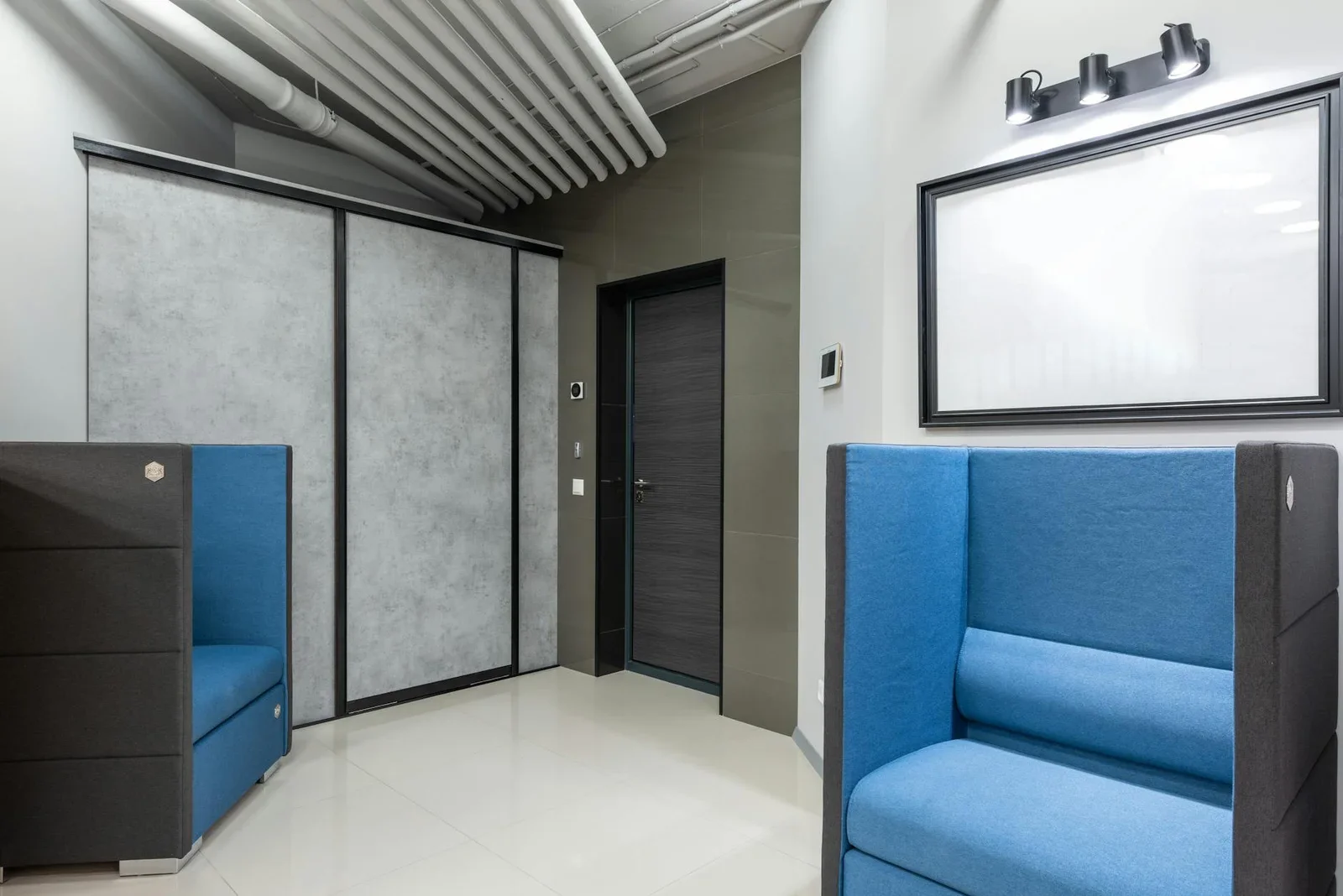 Sảnh đón hiện đại trang bị ghế bành xanh pastel, tủ âm tường tiện nghi và cửa kính rộng rãi, nâng tầm trải nghiệm khách hàng. | Thiết kế nội thất 24