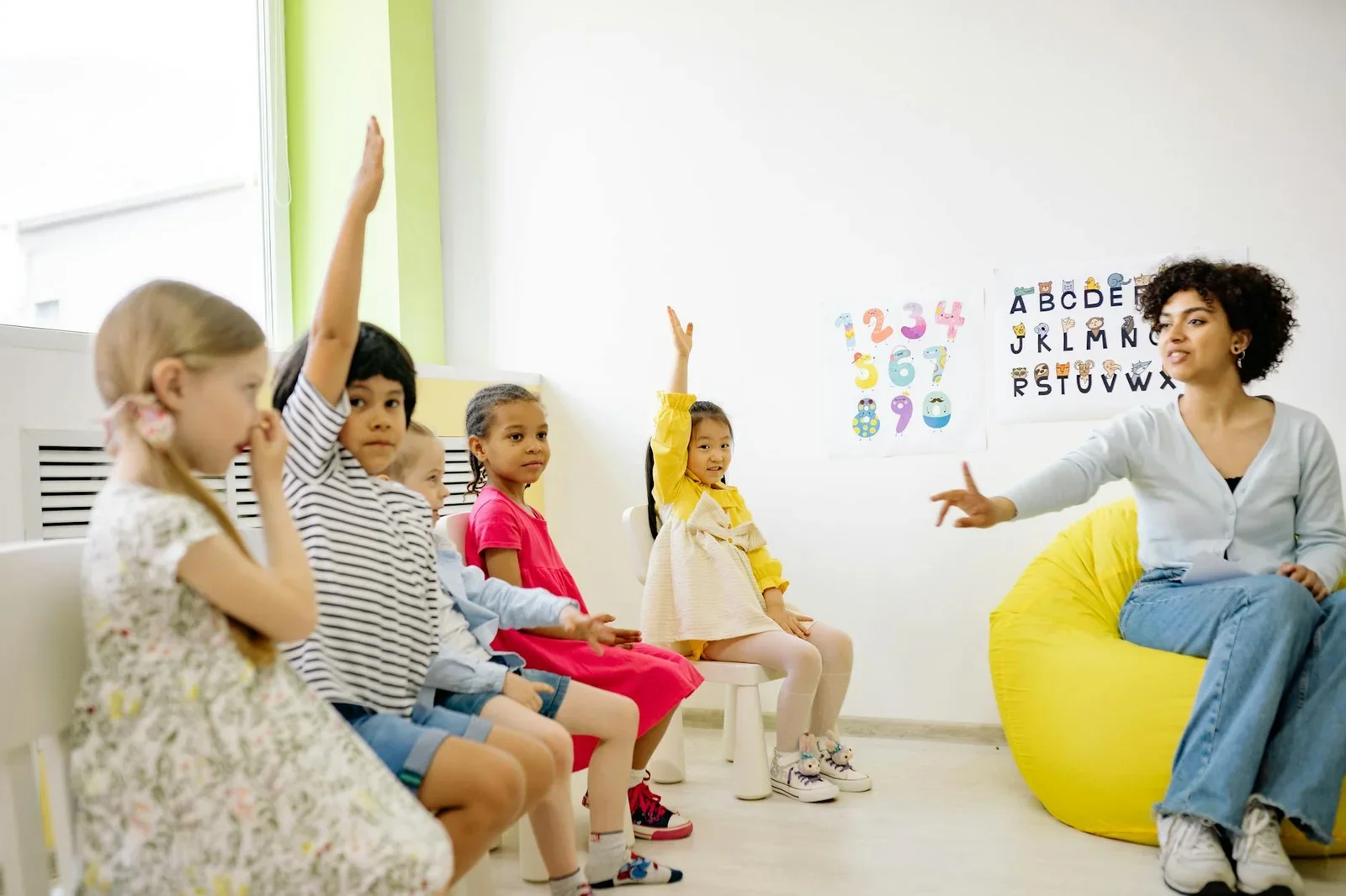 Phòng học bố trí bàn ghế bán nguyệt hướng về bục giảng, ánh sáng đồng đều hỗ trợ tương tác đa chiều giữa cô trò. | Thiết kế nội thất 24