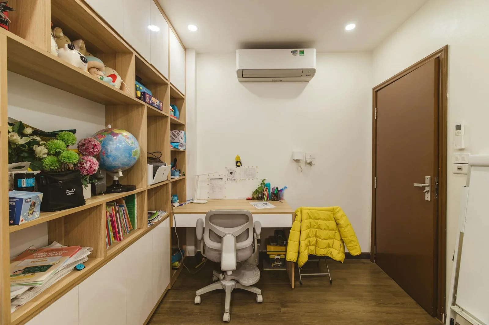 Góc làm việc hiện đại bố trí kệ gỗ ngăn nắp, bàn rộng rãi cùng điểm nhấn sắc vàng tươi mới khơi nguồn cảm hứng. | Thiết kế nội thất 24