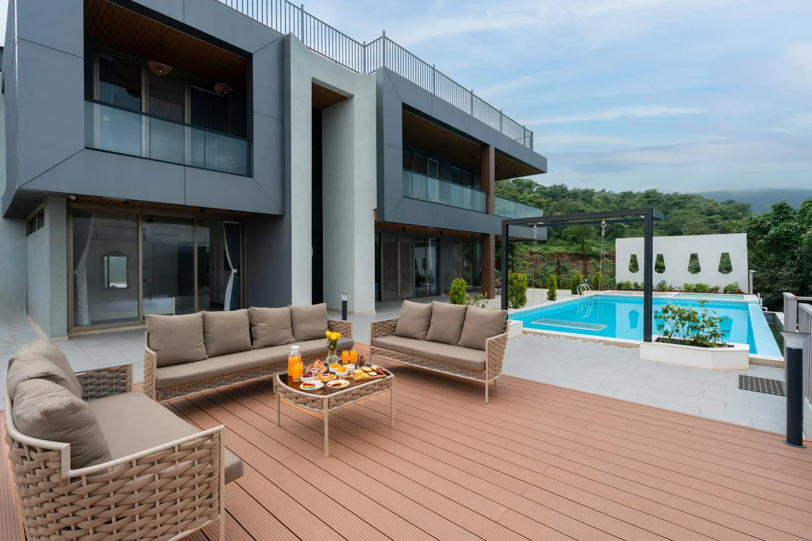 Khu vực hiên ngoài trời phong cách đương đại, bố trí bộ bàn ghế thư giãn cạnh hồ bơi, kết nối hài hòa với khối kiến trúc. | Thiết kế nội thất 24
